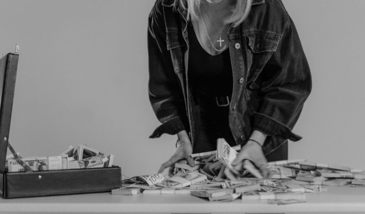 monochrome photo of person holding bundles of cash money